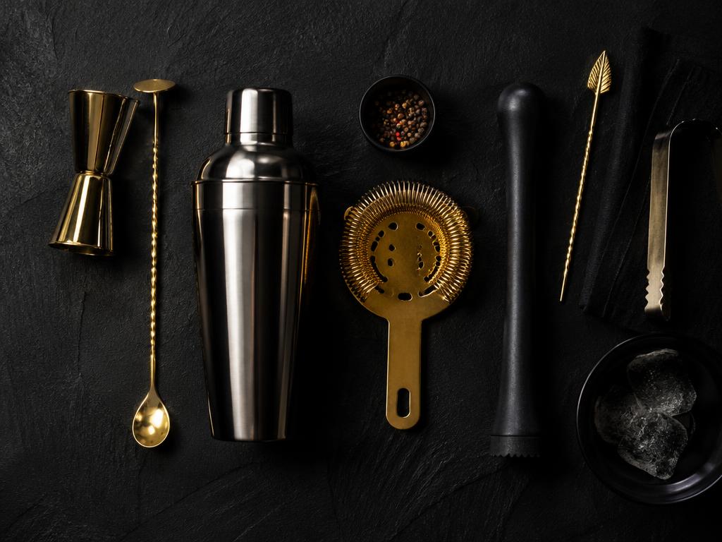 Bartools op zwarte leisteen: jigger, shaker, barlepel en strainer